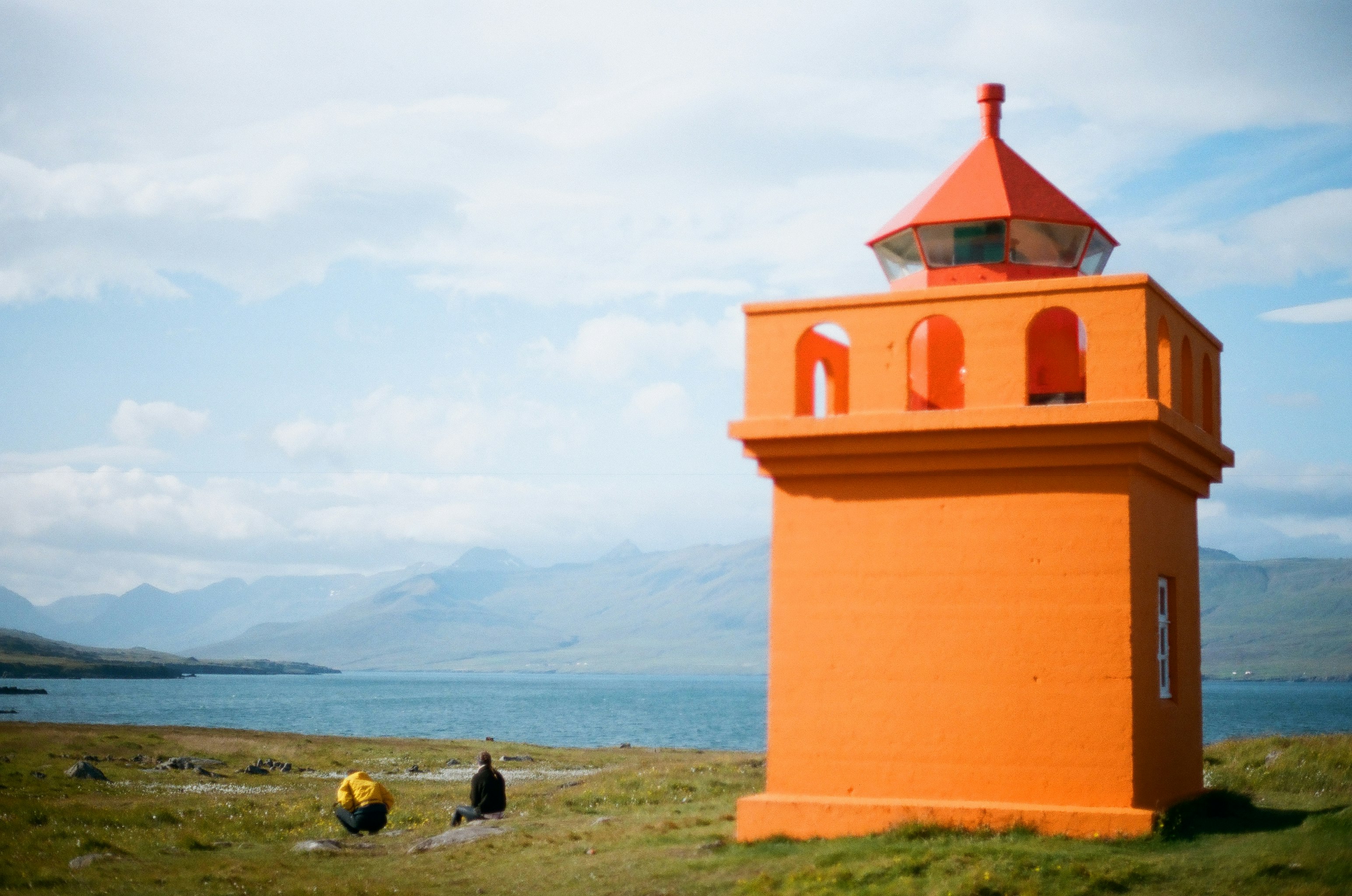 orange and white concrete building near body of water during daytime