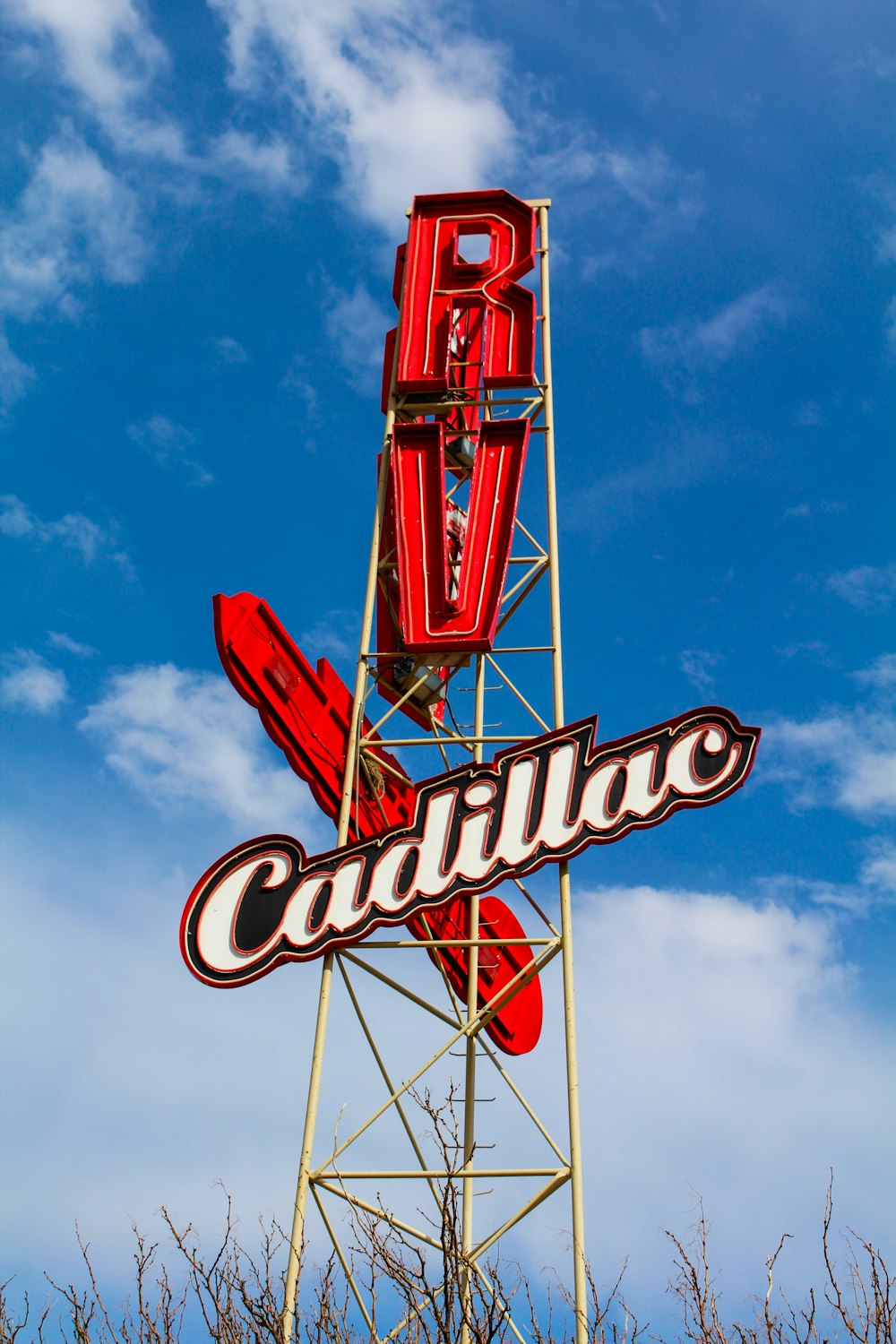 a red and white sign that says cadillac on it