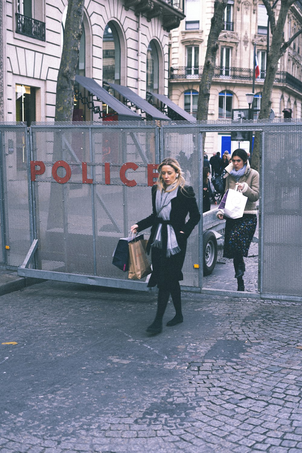 Femme en veste noire et pantalon noir portant un sac à main en cuir marron