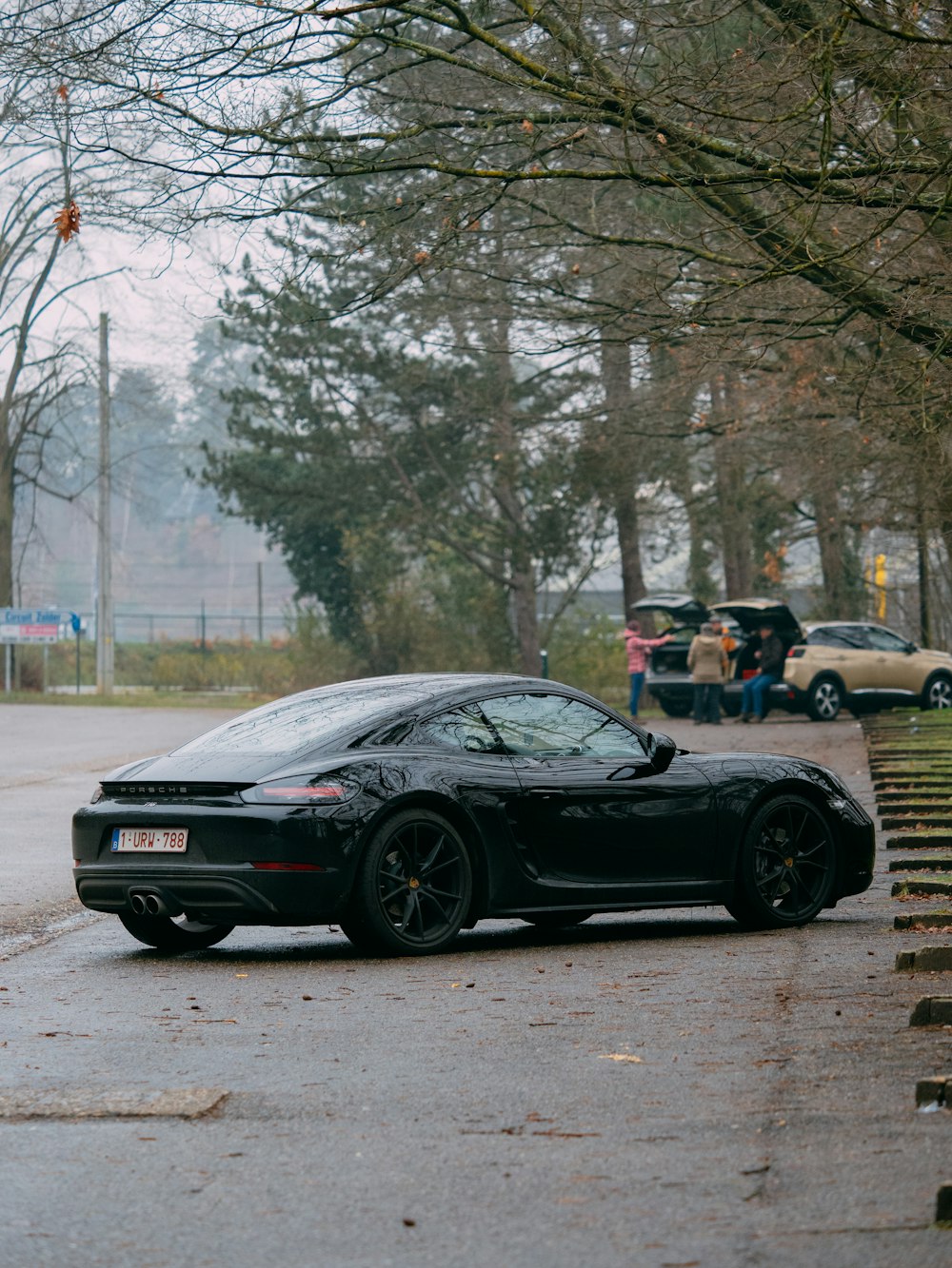 black bmw m 3 coupe parked on road near trees during daytime