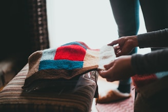 person holding white blue and red plaid textile