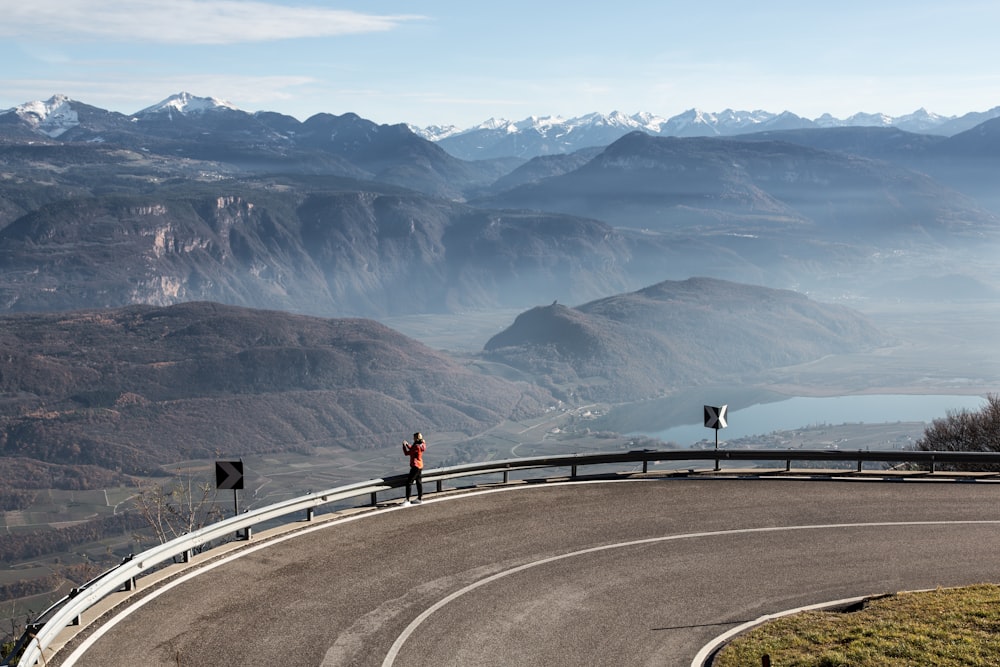 2 people walking on road near mountains during daytime