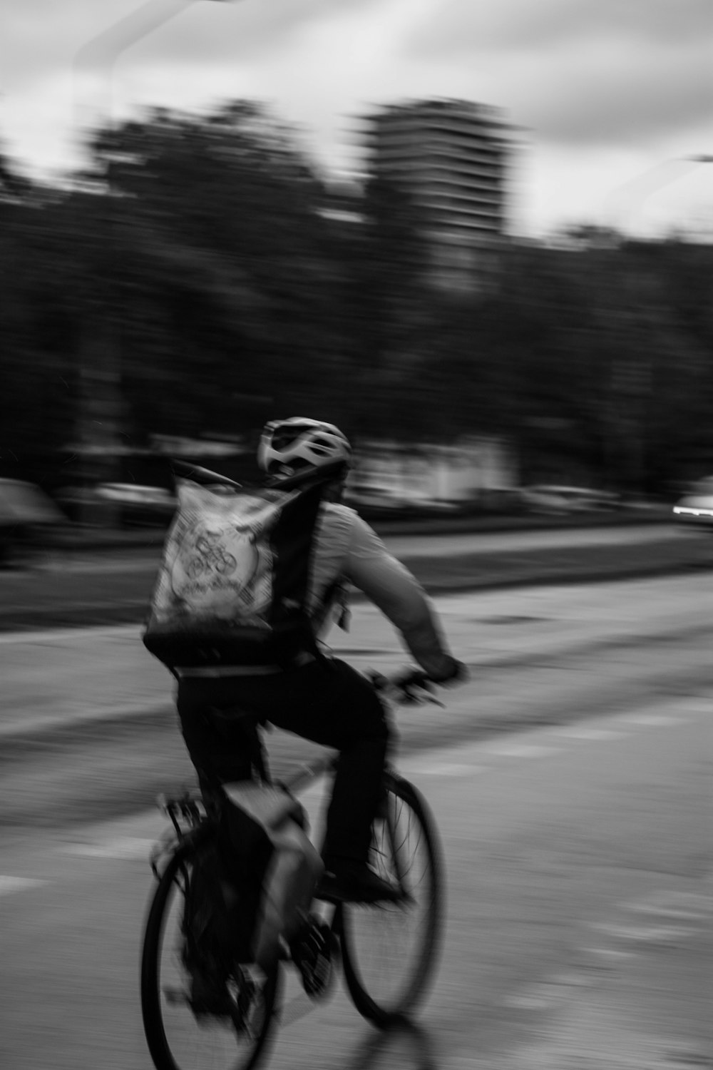 grayscale photo of man riding bicycle