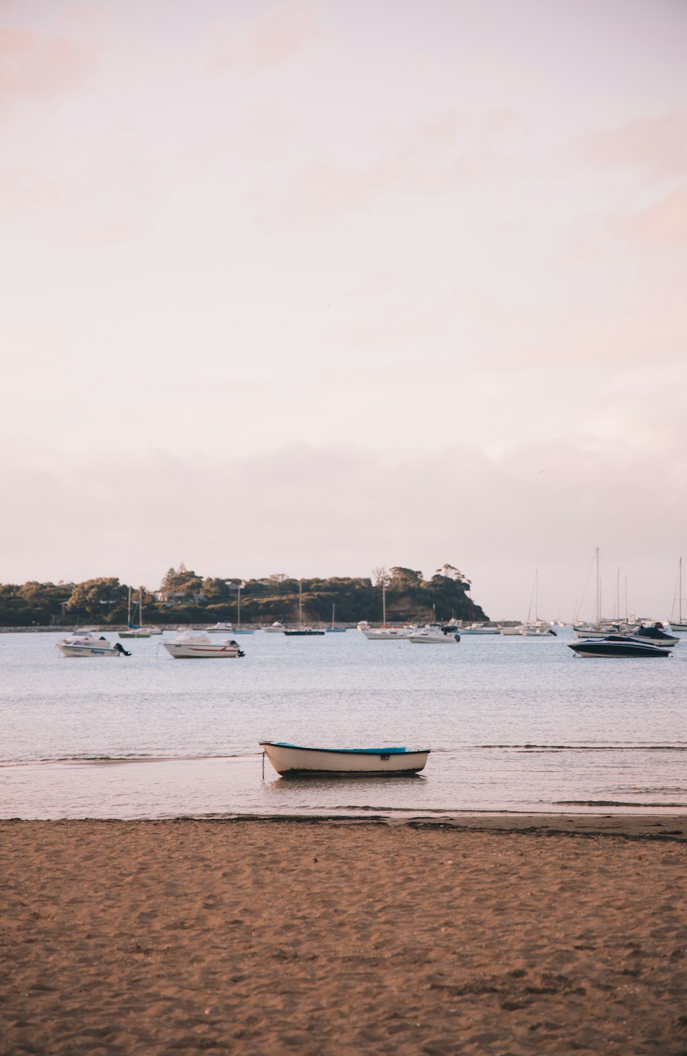 white and blue boat on sea shore during daytime