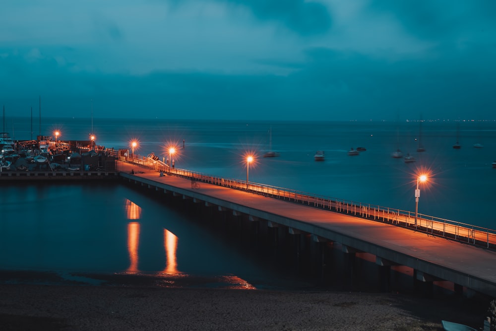 brown wooden dock on sea during sunset