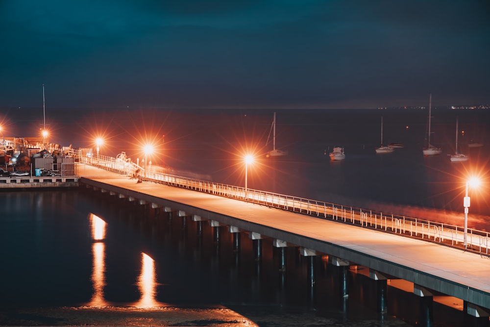 white bridge over body of water during night time