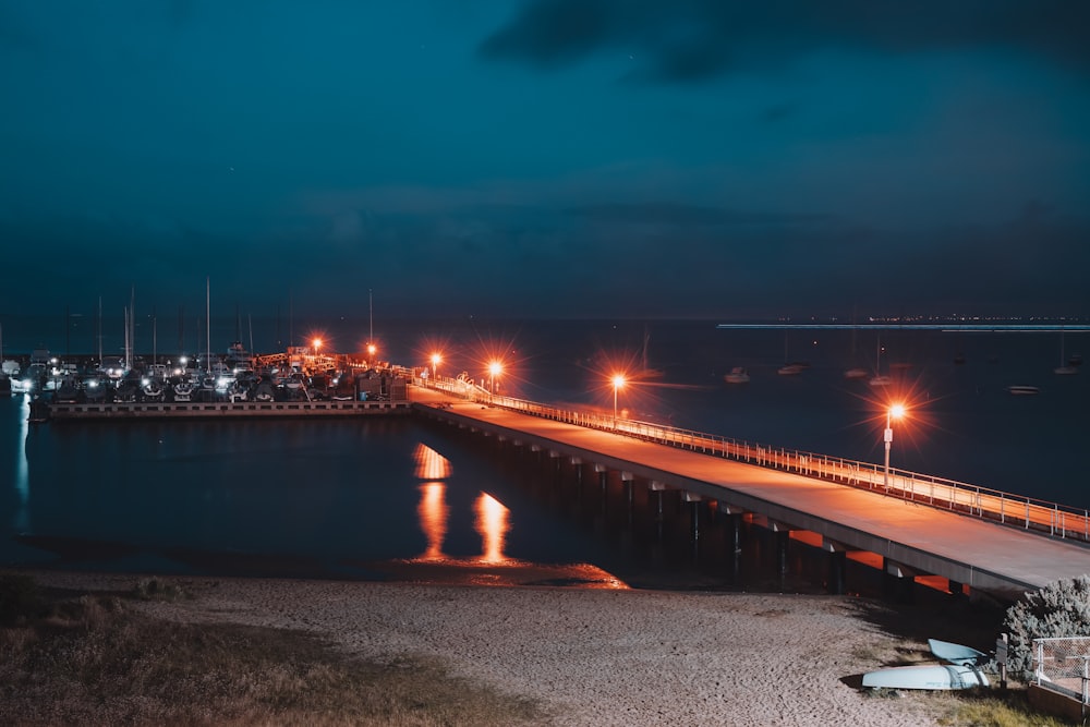 Puente iluminado sobre el cuerpo de agua durante la noche