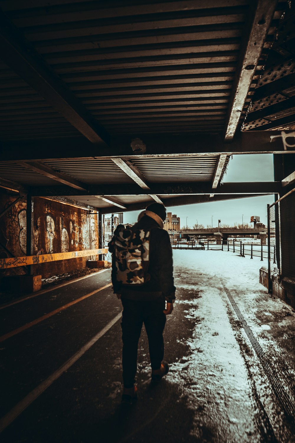 person in black jacket and black pants standing on snow covered ground during daytime