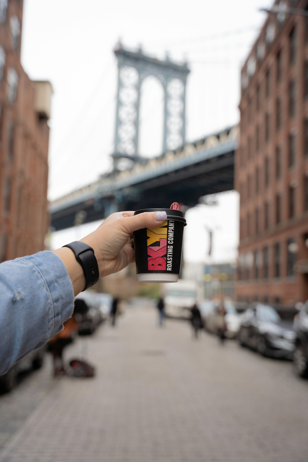 person holding black and red labeled can