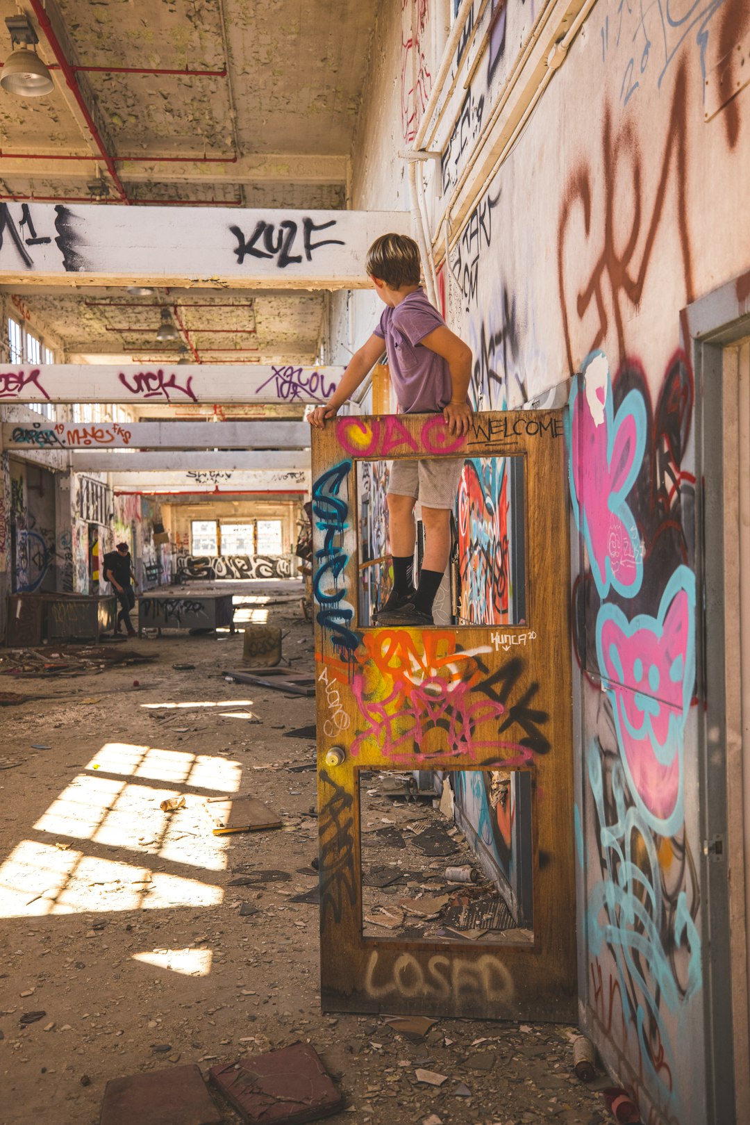 man in brown jacket standing beside graffiti wall during daytime