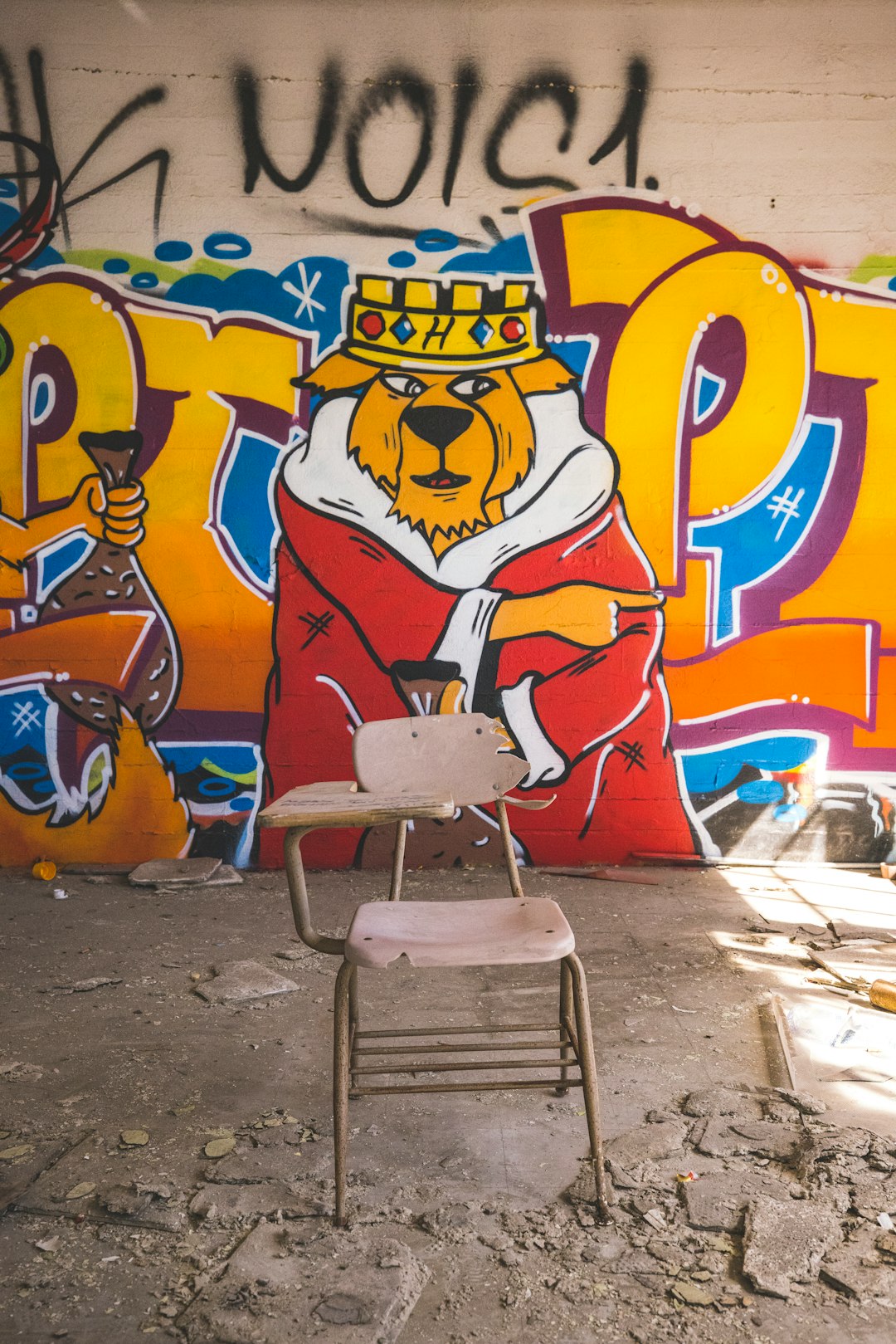 white and gray chair beside wall with graffiti