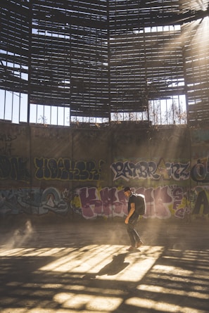 A survivor scavenging loot inside a dilapidated building with sunlight filtering through broken windows