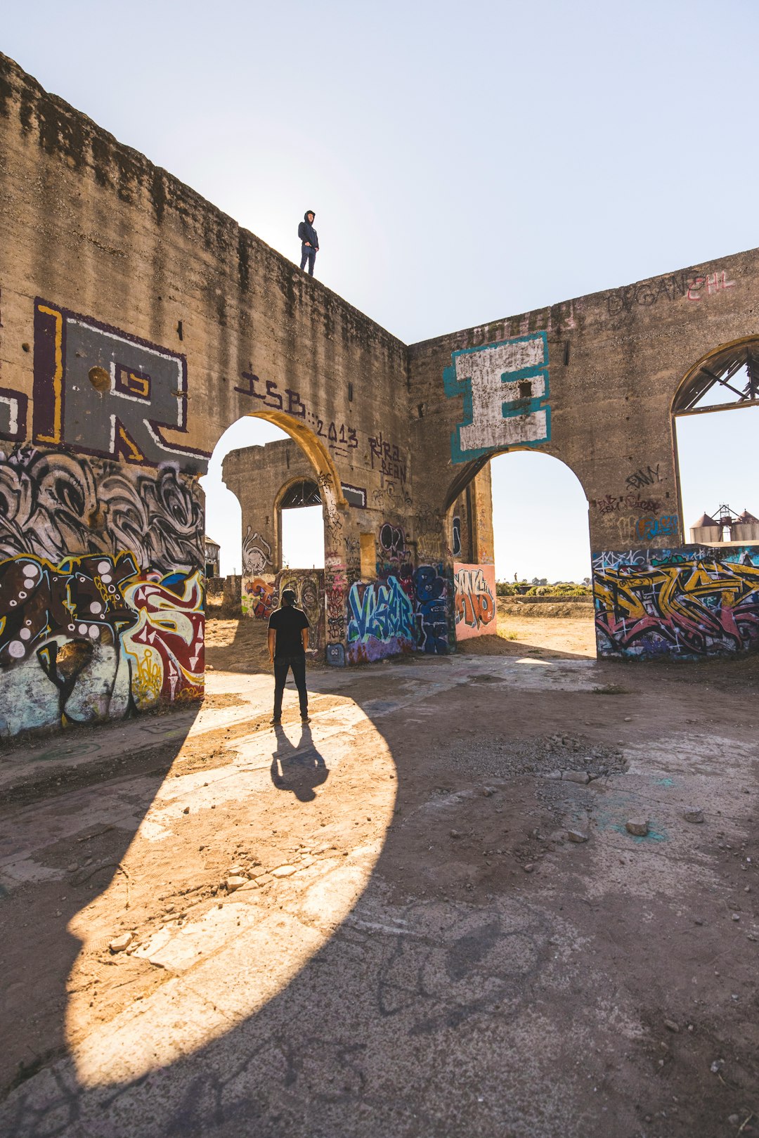 man in black jacket standing near brown concrete building during daytime