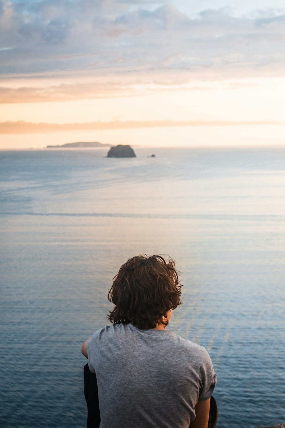 woman in white shirt looking at the sea during daytime