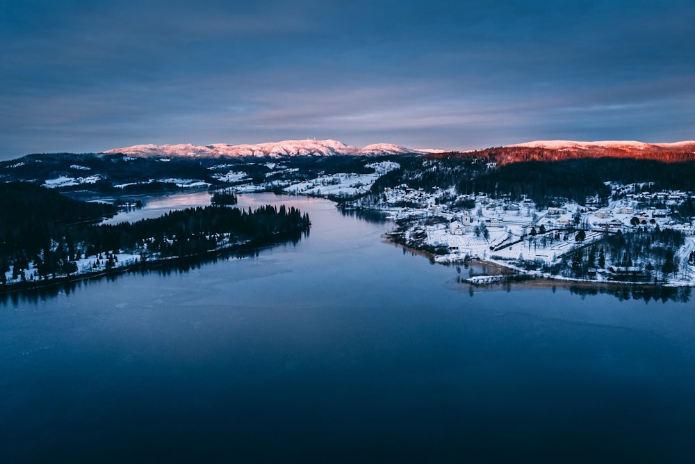 body of water near mountain during daytime