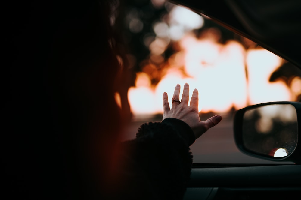 person in black long sleeve shirt raising hand