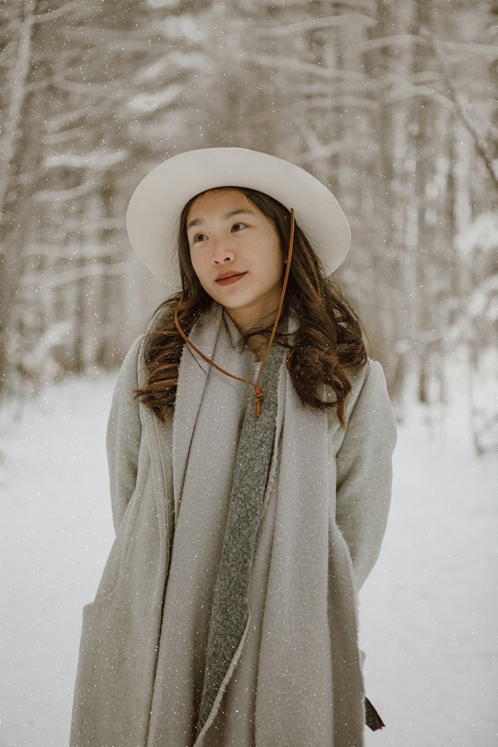 woman in white coat standing on snow covered ground during daytime