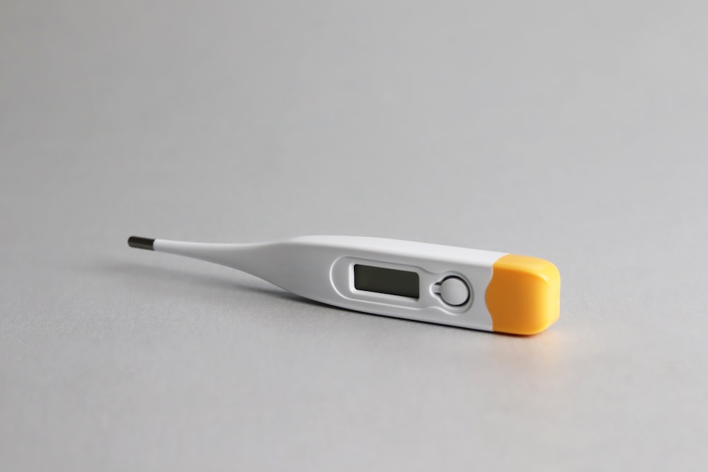 white and yellow thermometer on white surface