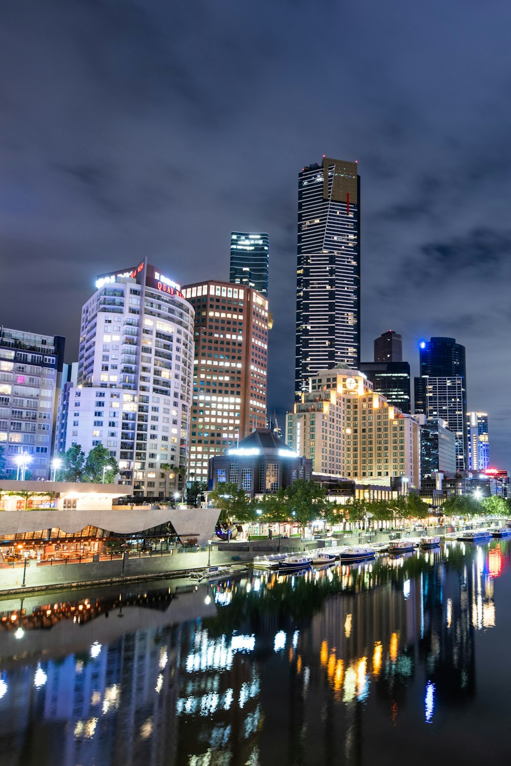 city buildings near body of water during night time