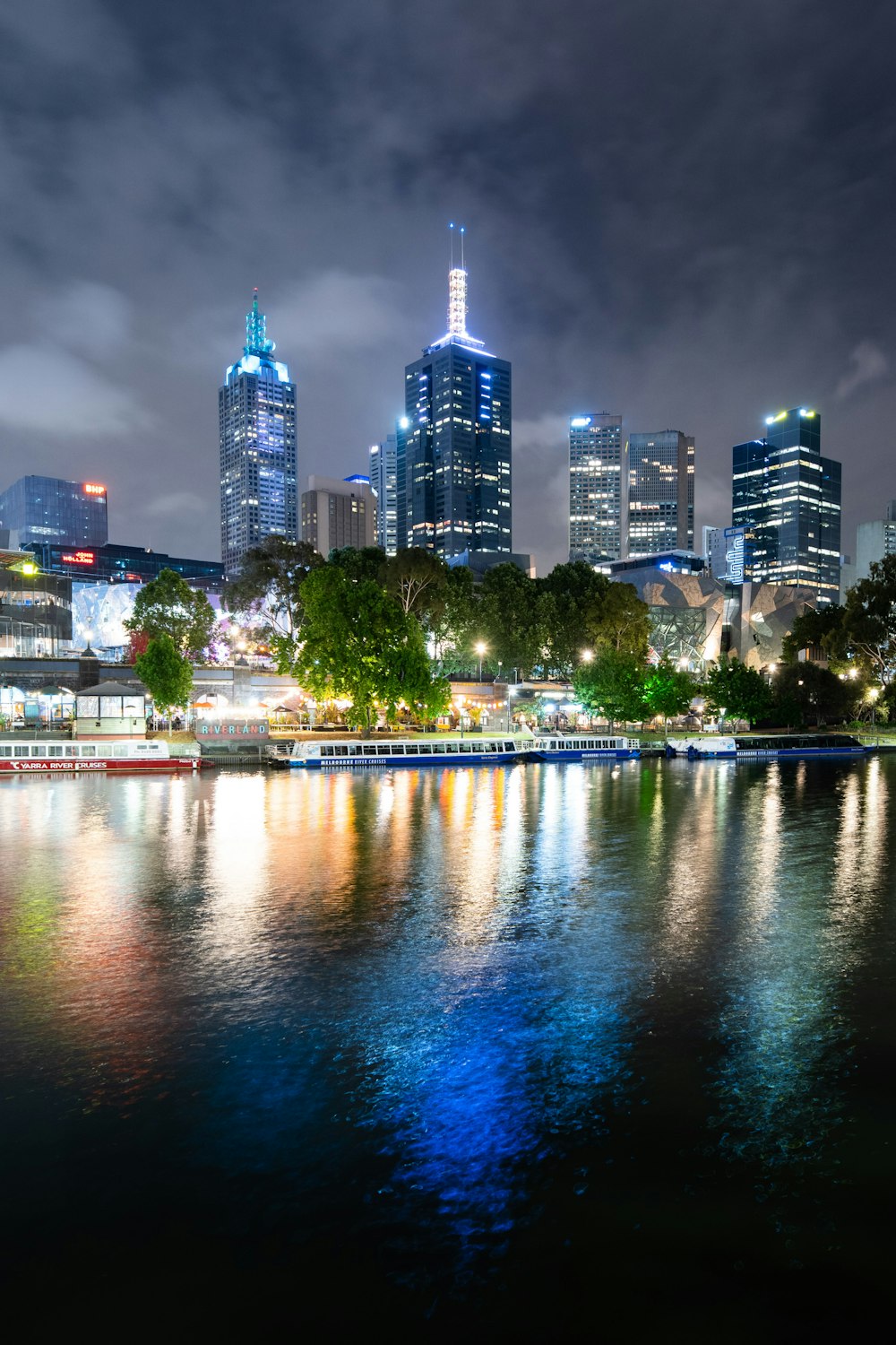 city skyline across body of water during night time