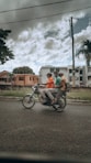 man in green t-shirt riding on black motorcycle during daytime