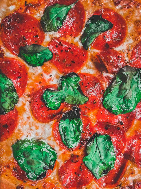 Close-up of a wood-fired pizza with tomato and basil