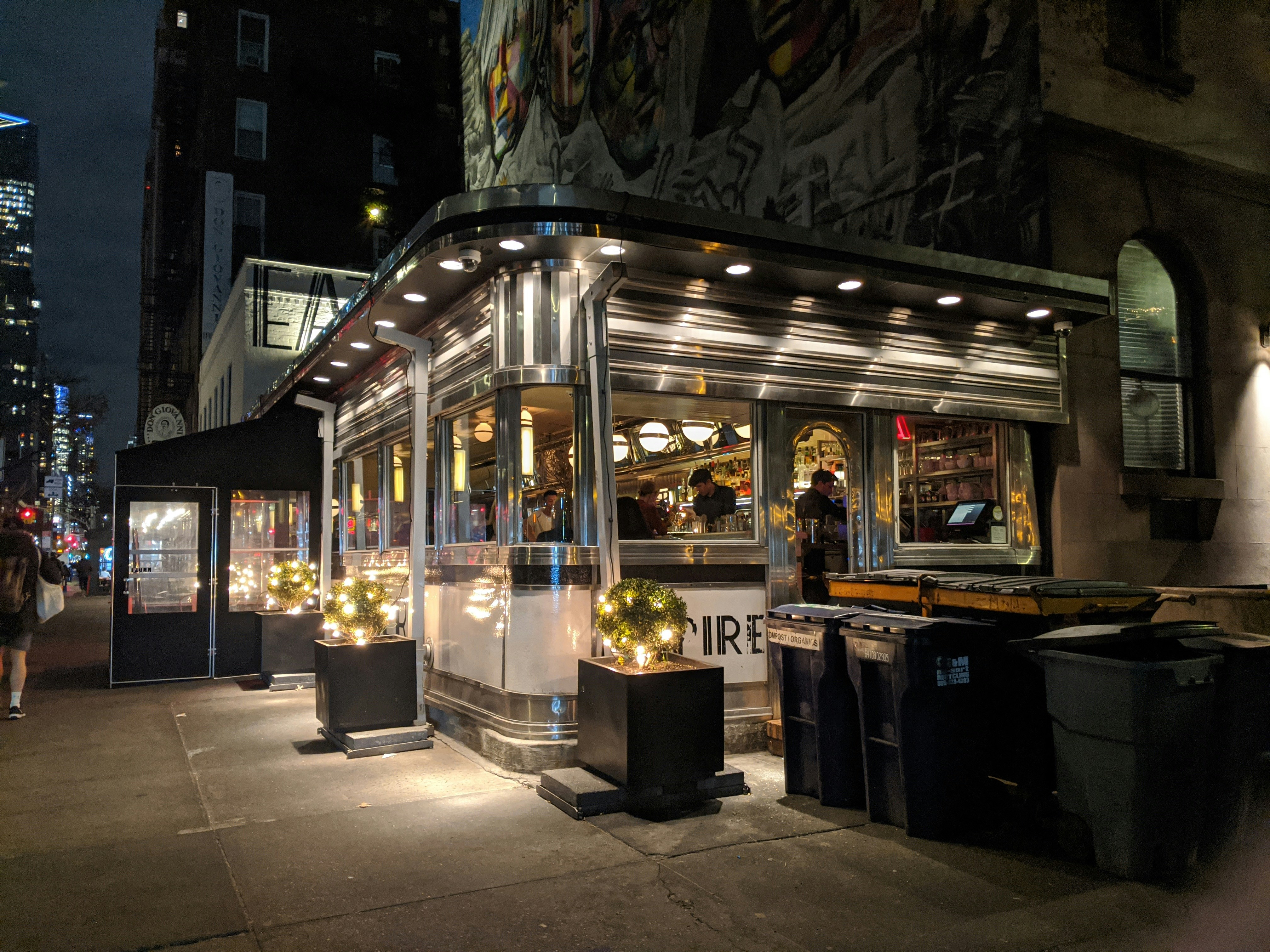 people in restaurant during night time, The Empire Diner at night in Chelsea, Manhattan, NYC. Photographed in January, a sidewalk vestibule is seen in front of the entrance to insulate diners from the cold winter air.</p><p>Also available on Wikimedia Commons and Flickr: <<< https://www.flickr.com/photos/191620418@N06/50798342571/in/dateposted-public/ >>> <<< https://upload.wikimedia.org/wikipedia/commons/0/08/Empire_Diner_at_night.jpg >>>