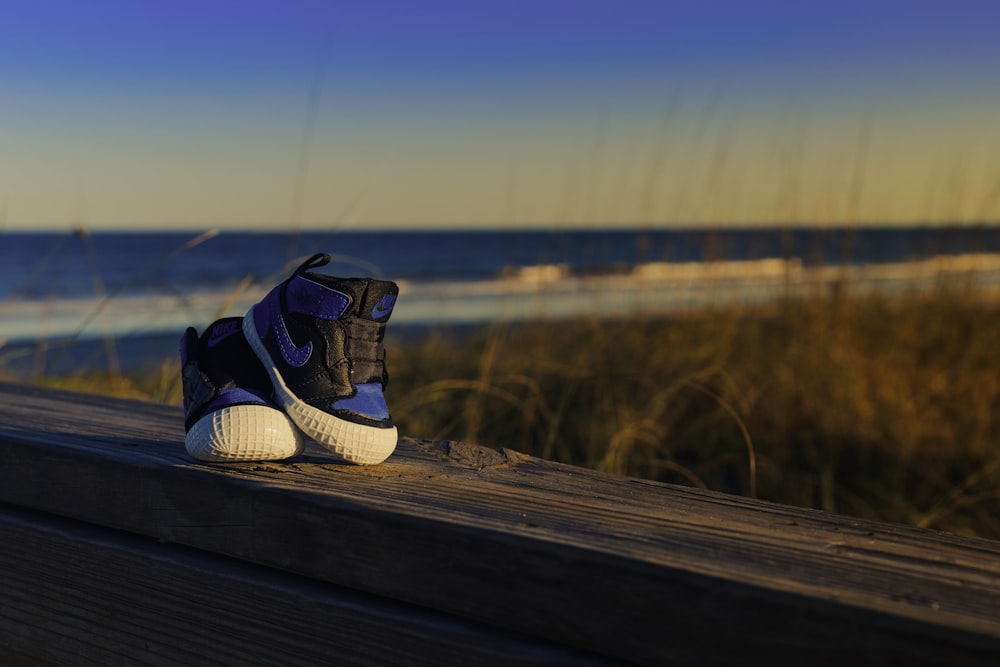 white and blue adidas sneakers on brown wooden plank during daytime