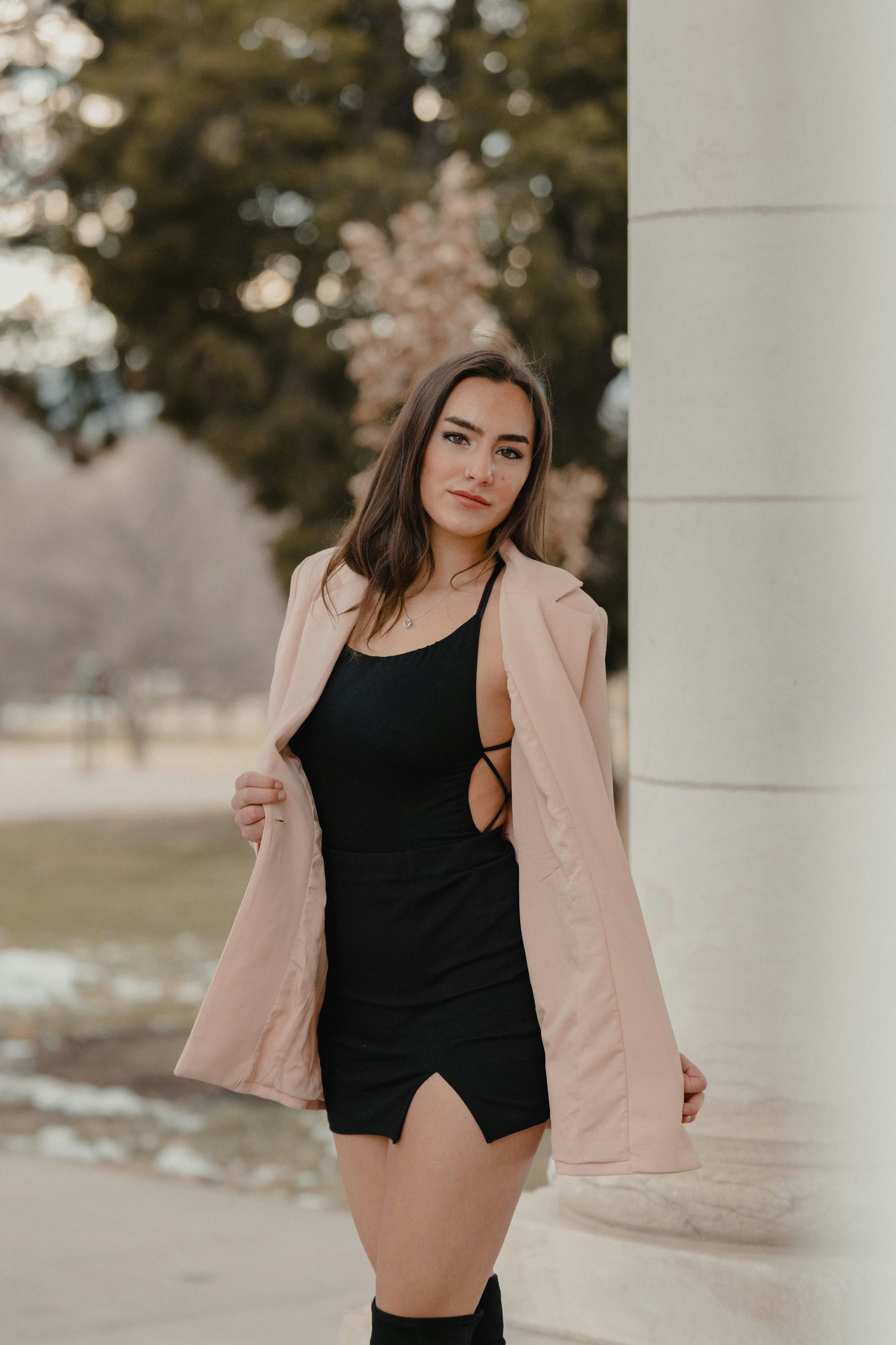 Woman in black tank top and pink blazer standing near white concrete wall  during daytime photo  Free Grey Image on Unsplash