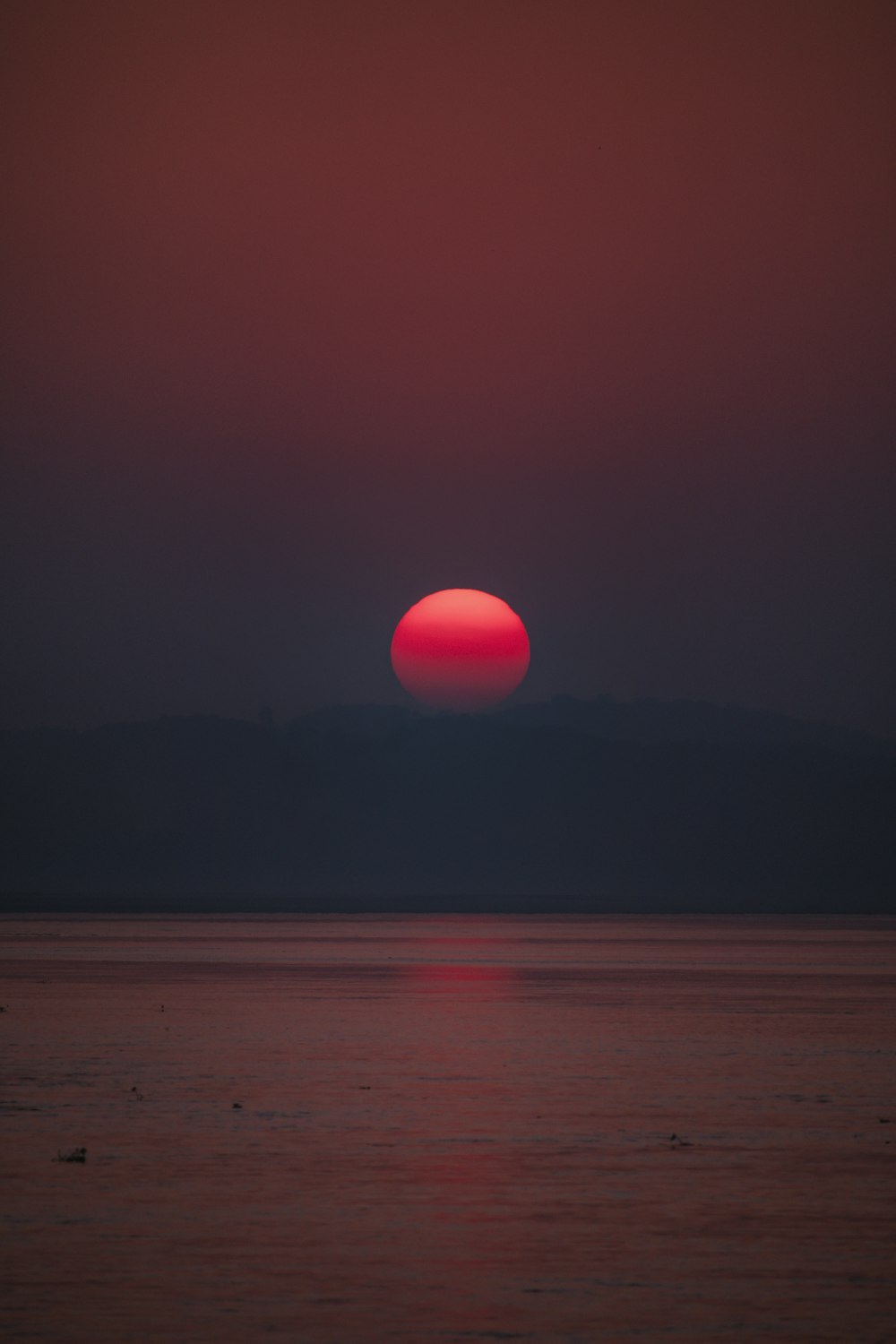 sunset over the mountain and body of water