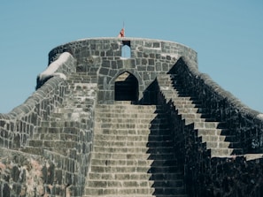 a man standing on top of a stone wall