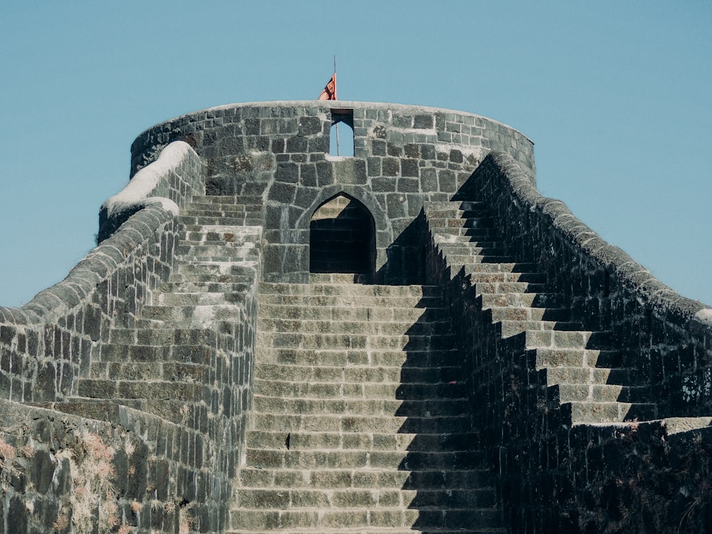 a man standing on top of a stone wall