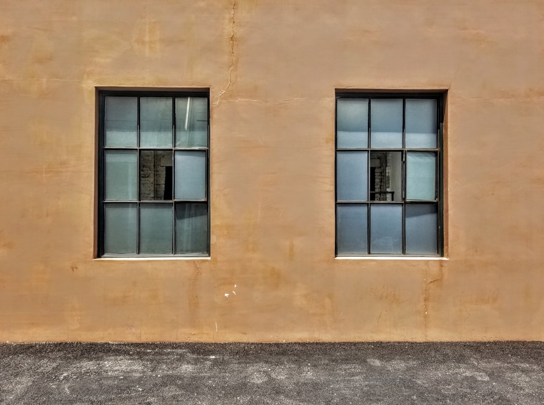 black framed glass window on brown concrete building