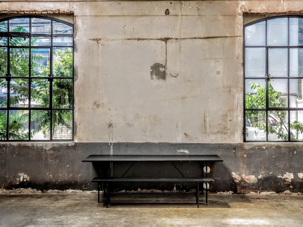 black wooden bench near brown concrete wall