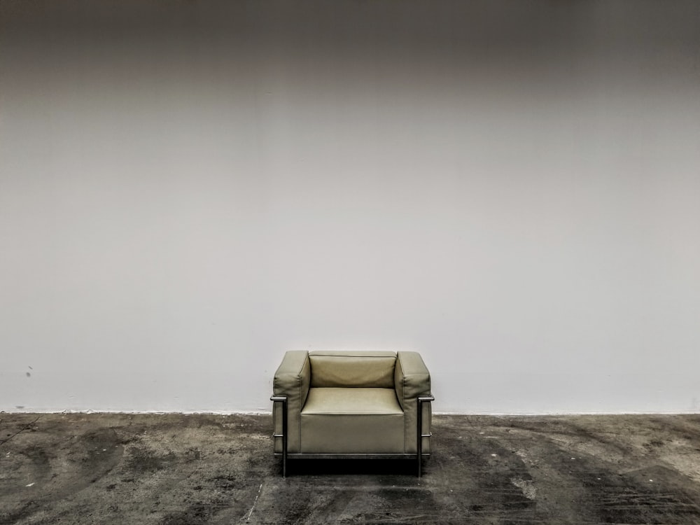 white padded armchair on brown sand