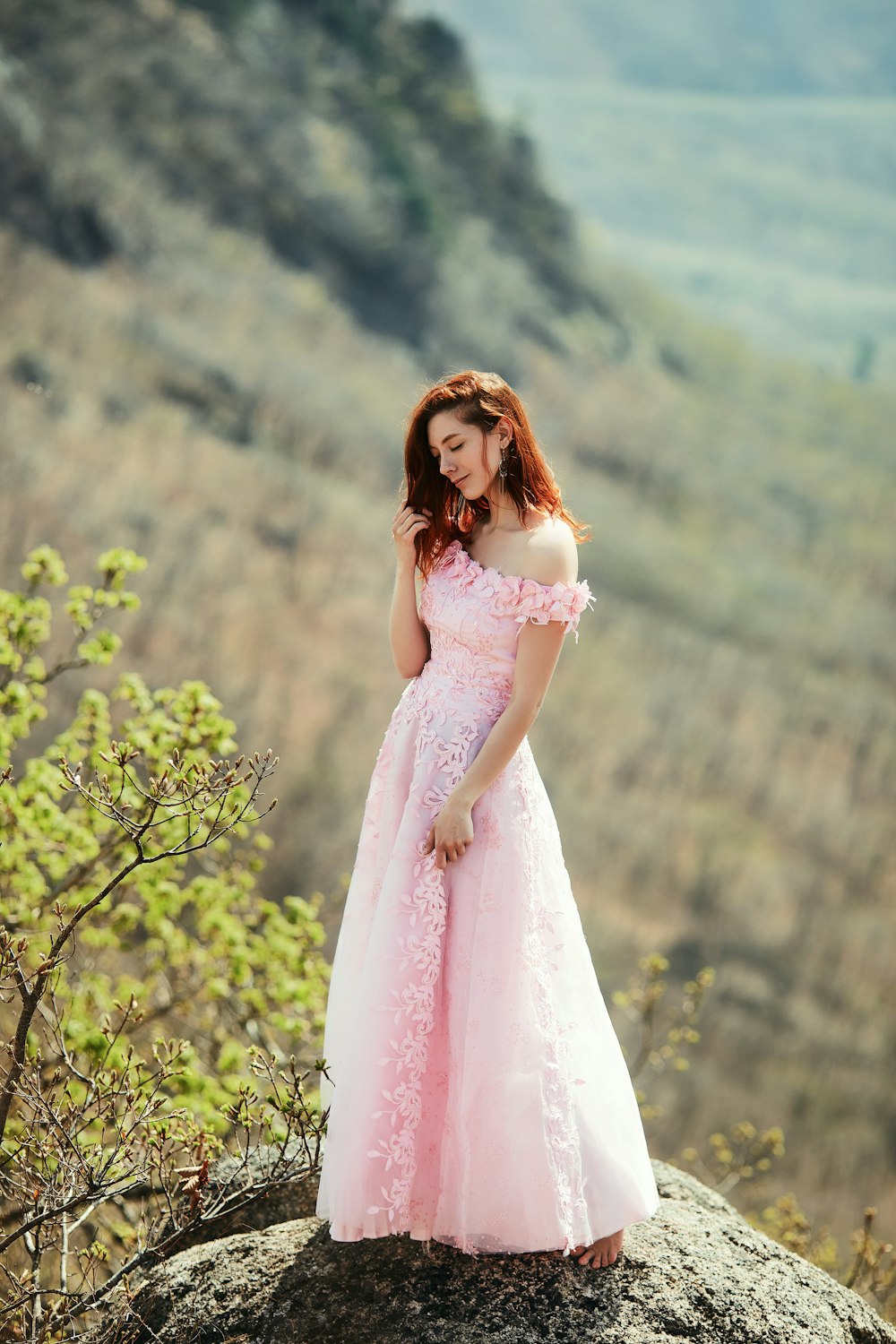 Frau in rosa Kleid, die tagsüber in der Nähe von Green Tree steht