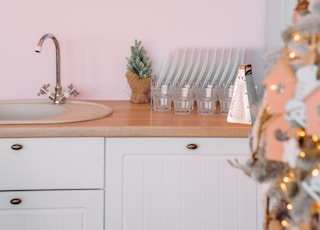 a kitchen with pink walls and white cabinets