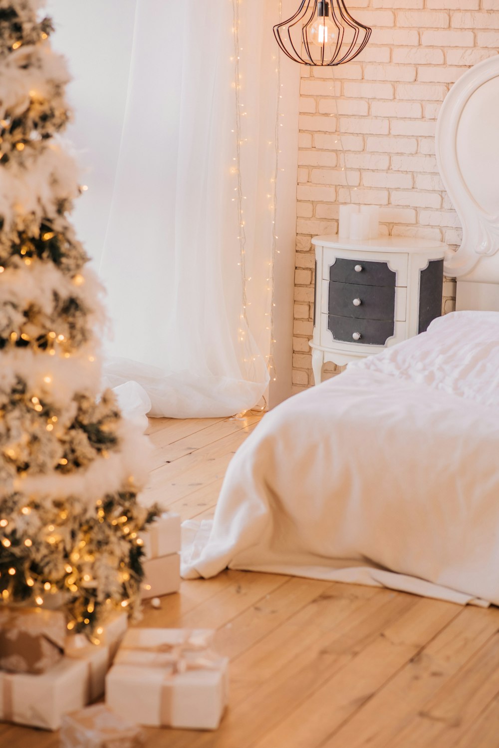 크리스마스 트리 근처의 흰색 침대