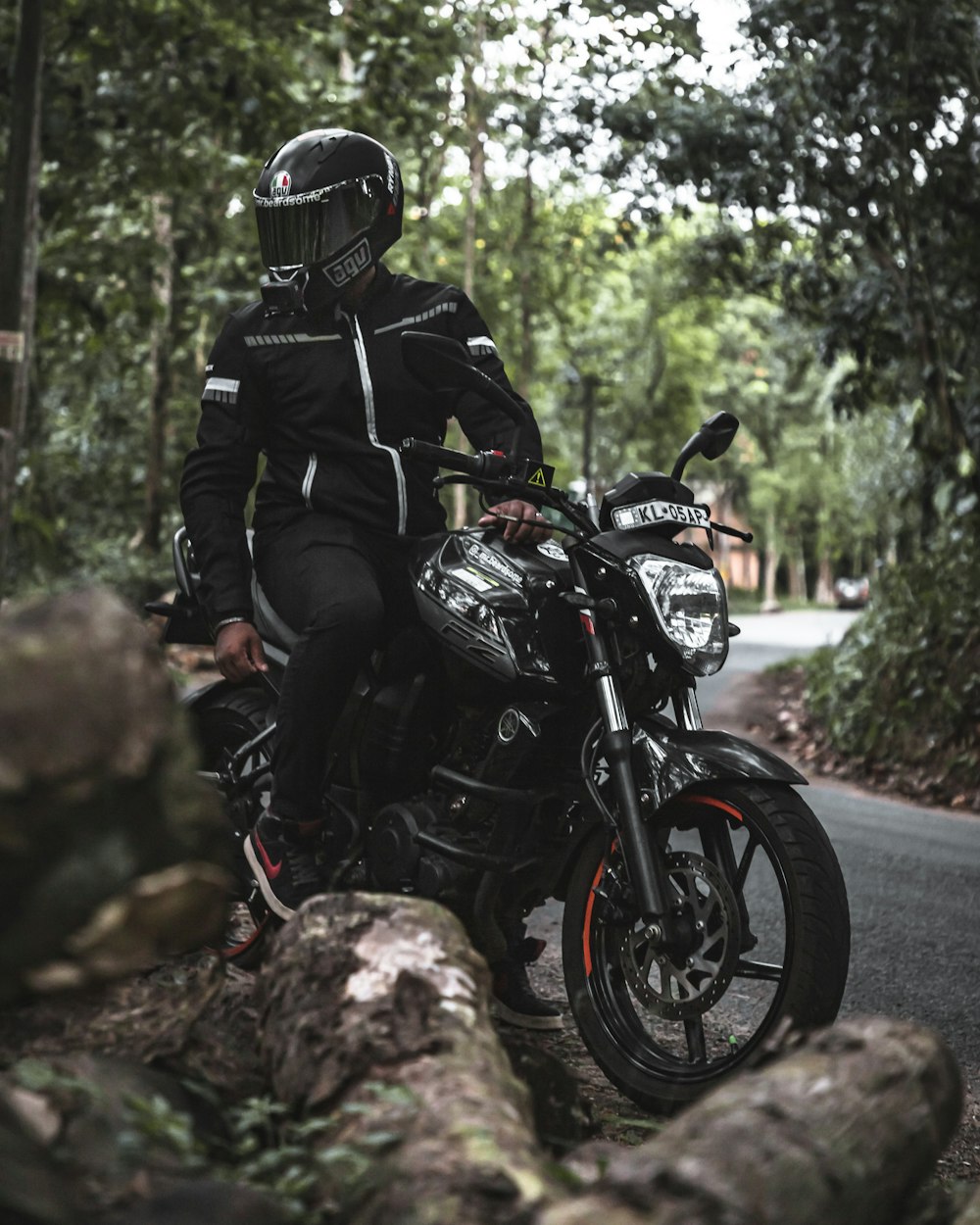 man in black jacket and helmet riding black motorcycle