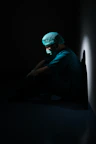 man in green shirt and blue knit cap sitting on floor