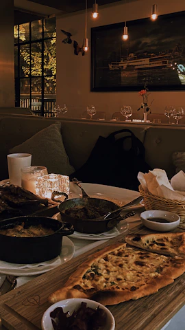 A rustic wooden table filled with colorful mezze dishes under warm lighting.
