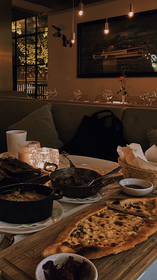 Warm, soft-lit photo of a cozy Scandinavian-style restaurant table set with artisanal dishes and rustic tableware.