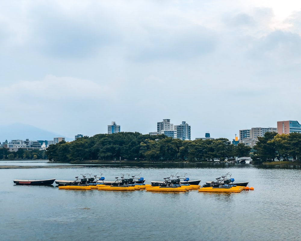yellow and black boat on water near city buildings during daytime