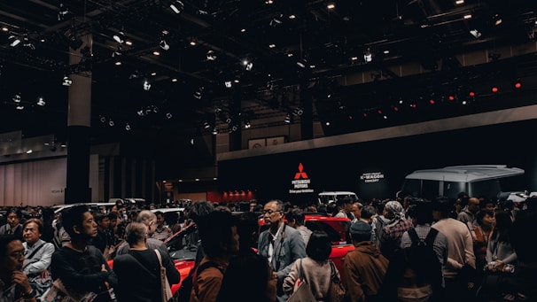 A bustling exhibition floor with vibrant booths displaying automotive parts and technology.