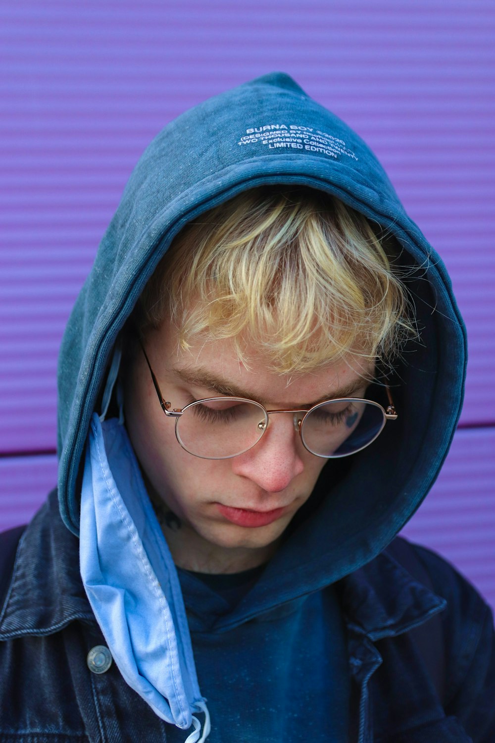 blonde haired woman in blue hoodie wearing black framed eyeglasses