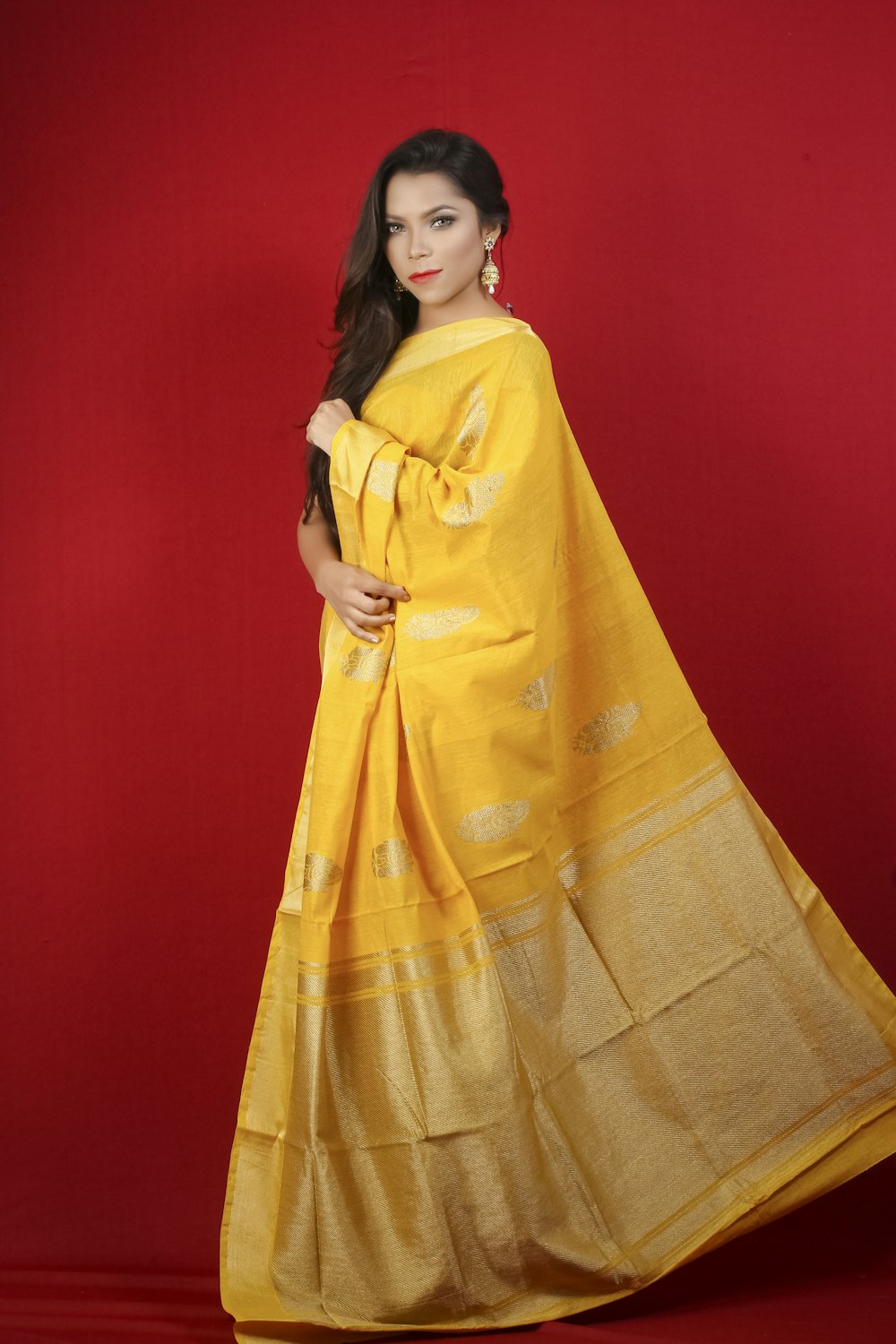 woman in yellow and brown sari standing