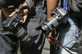 person in black jacket holding black dslr camera