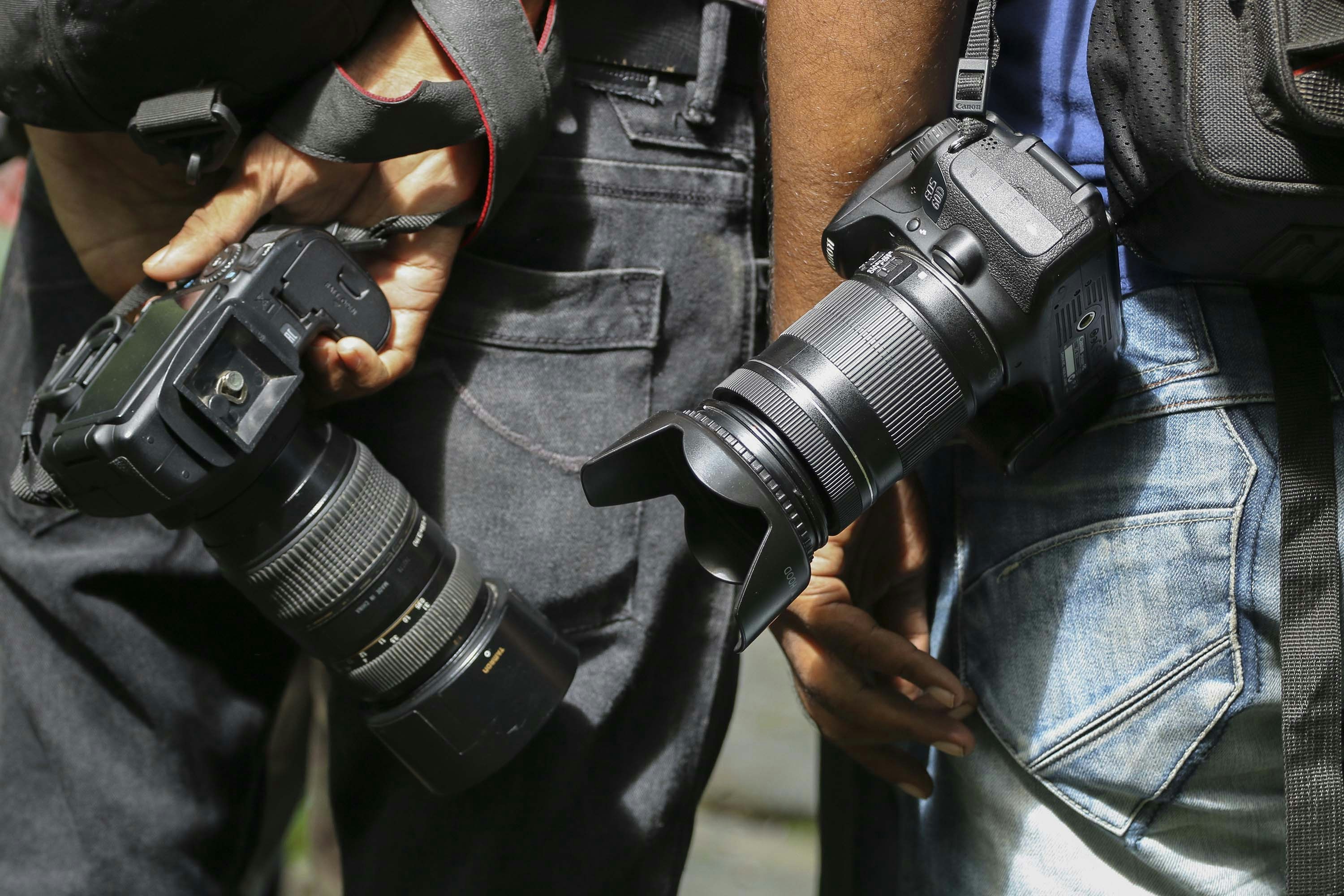 person in black jacket holding black dslr camera