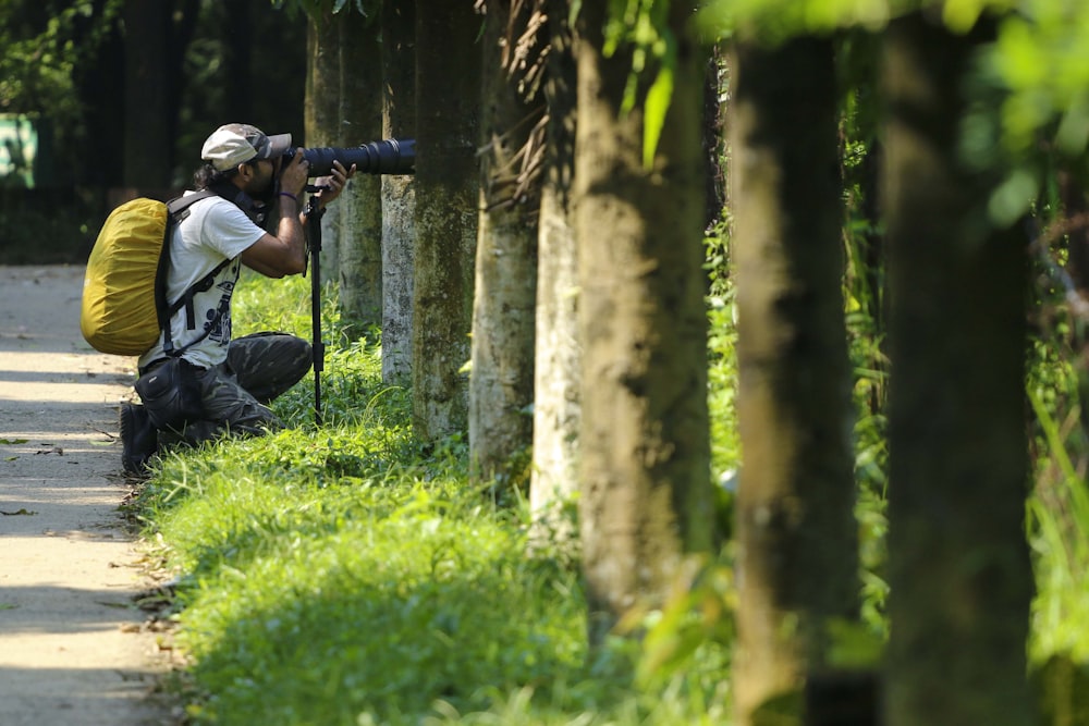 homme en veste noire et pantalon noir assis sur le terrain d’herbe verte