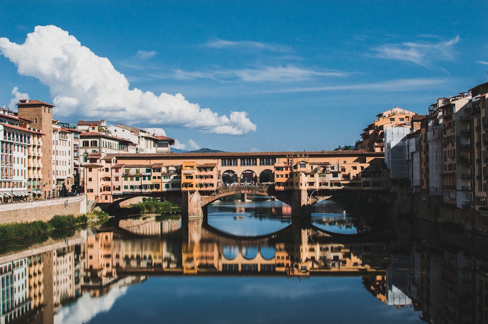 Edificio in cemento marrone vicino allo specchio d'acqua sotto il cielo blu durante il giorno